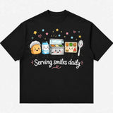 Printora UK black heavyweight cotton T-shirt featuring a cute cartoon school lunch graphic and Serving Smiles Daily text