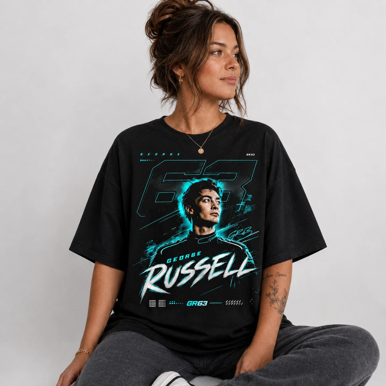 Seated female model wearing black GR63 racing graphic T-shirt