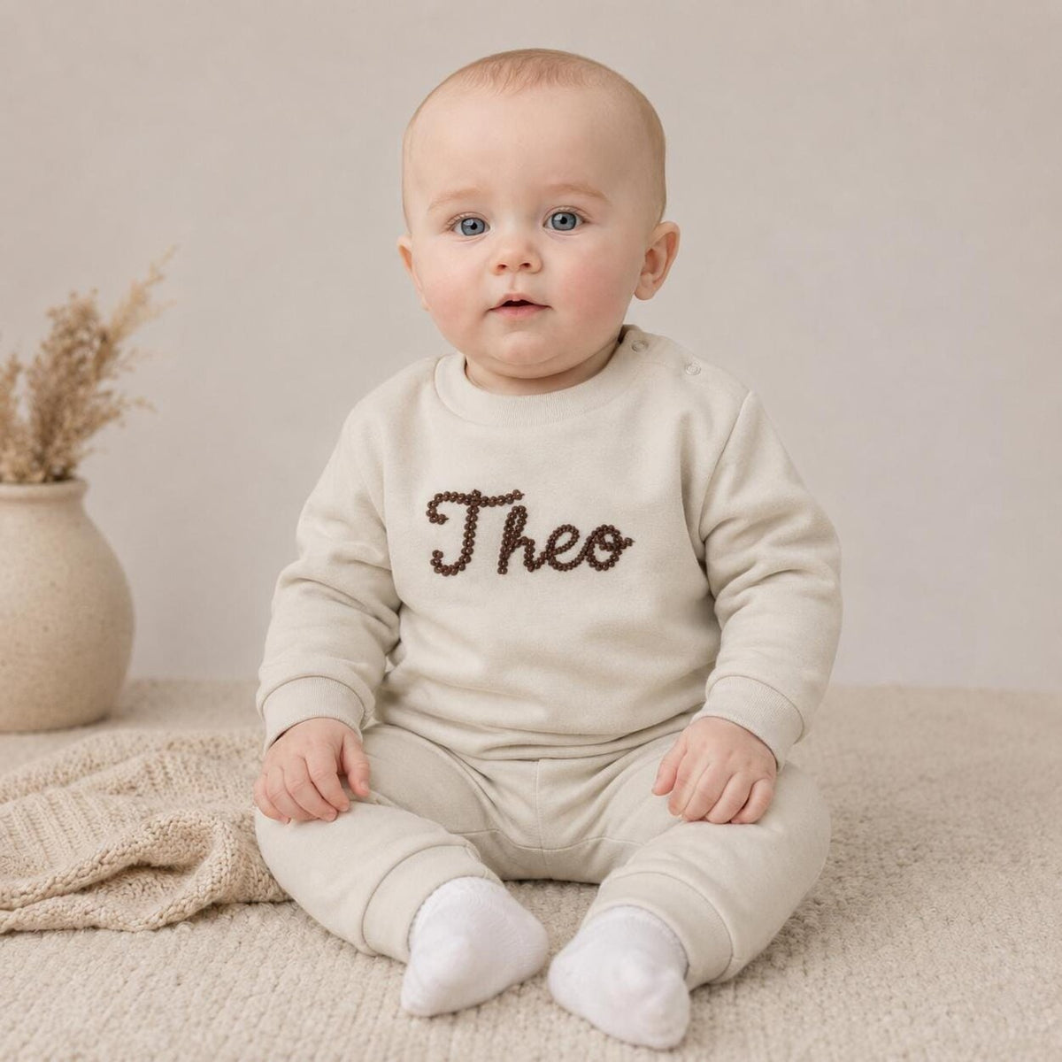 Personalised baby tracksuit in light stone worn by baby