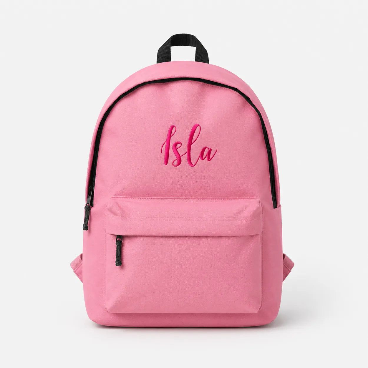 A pink canvas backpack with black trim, a top handle, and a front zippered pocket. The word 'Isla' is embroidered in pink script on the front.