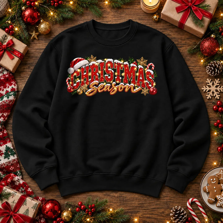 Black Christmas Season jumper with festive red Christmas lettering, gold script, holly and baubles on a classic crew-neck sweatshirt