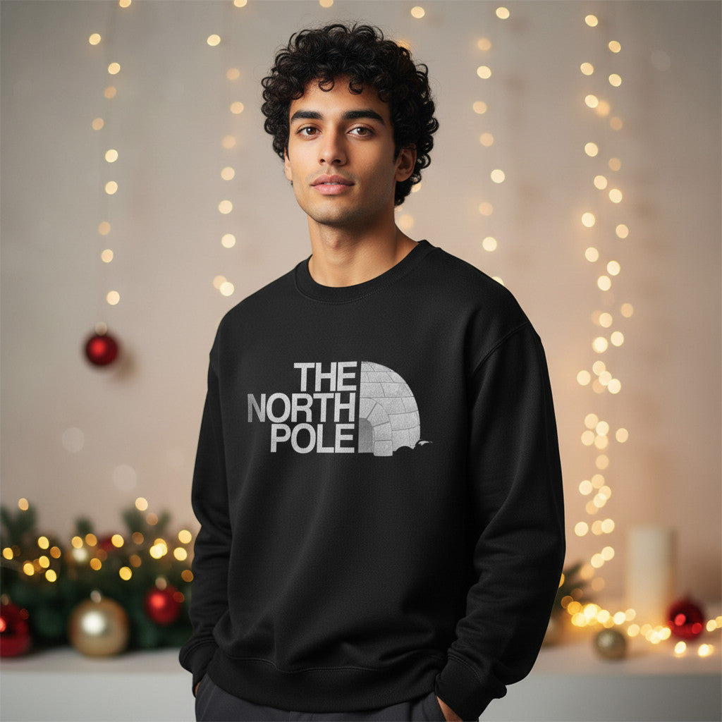 Printora UK black crew neck Christmas jumper with The North Pole igloo graphic worn by a man in a festive setting.